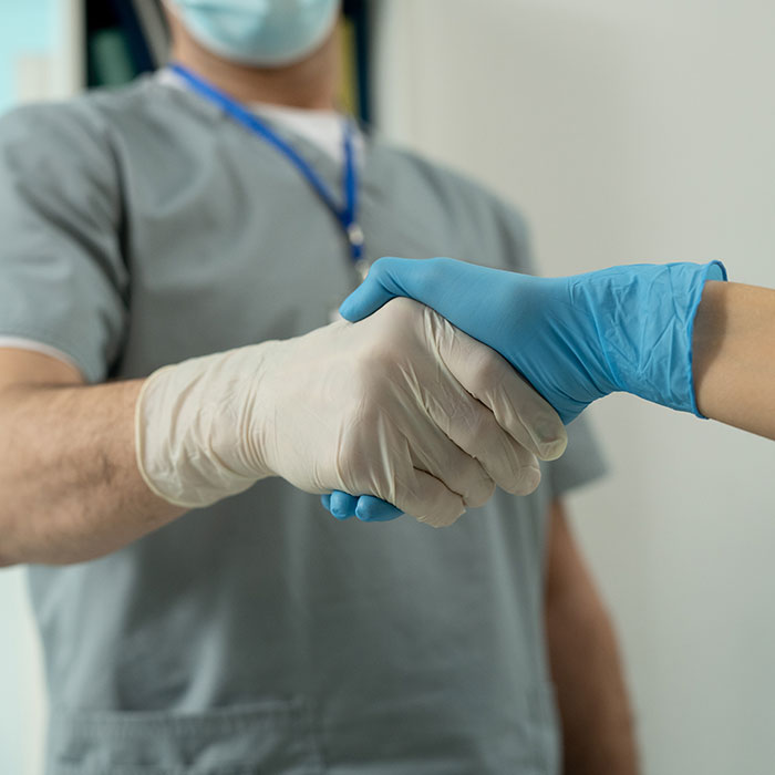 doctors shaking hands with gloves